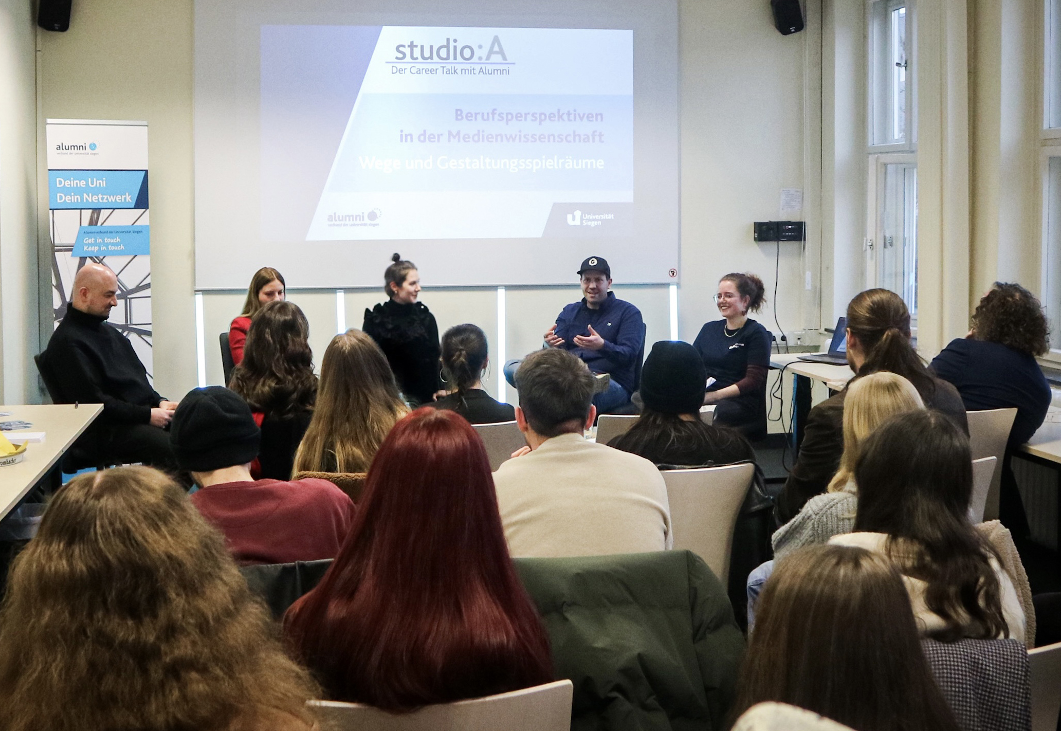 Die Gäse und Gästinnen sitzen mit der Moderatorin vor dem Publikum und unterhalten sich.