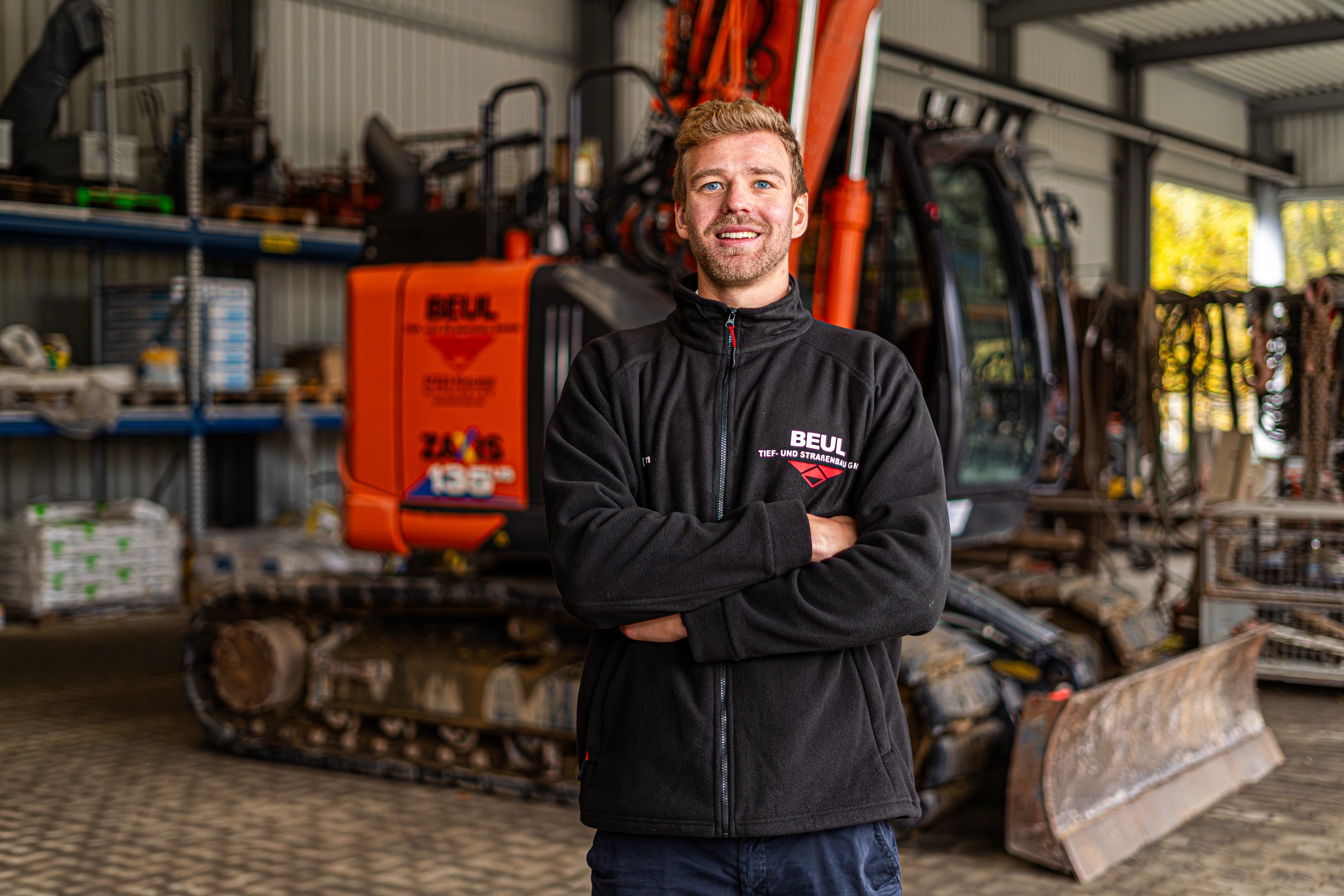 Studierender steht vor großer Baumaschine