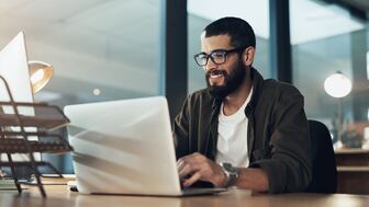 Studierender sitzt vor Laptop