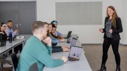 Studierende sitzen in einem Seminarraum an Tischen