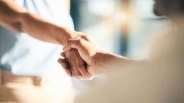 Zwei Menschen geben sich die Hand