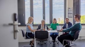 Ein Team der Verwaltung sitzt bei einer Besprechung am Tisch