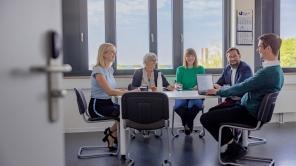 Ein Team der Verwaltung sitzt bei einer Besprechung am Tisch