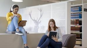 Zwei Studentinnen sitzen in der AR Biliothek und lesen