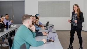 Studierende sitzen in einem Seminarraum an Tischen