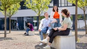 Drei Studieren unterhalten sich am Campus AR