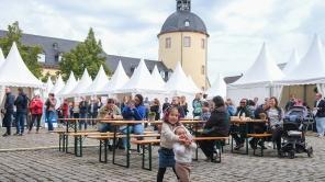 Schlossplatz mit Besucherinnen und Besuchern bei der Offenen Uni. Im Hintergrund die Zelte der Offenen Uni und der Dicke Turm.