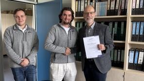 Professor Kluth erhält den Lehrpreis der Fakultät in seinem Büro überreicht