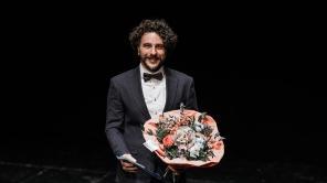 Preisträger Dr.-Ing. Peter Frohn-Sörensen auf der Bühne mit einem Blumenstrauß
