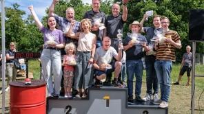 Die drei Gewinnerteams des Team-Wettbewerbs beim Beschäftigtenfest jubeln auf dem Podium.