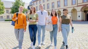 Fünf Studierende laufen über den Campus Unteres Schloss