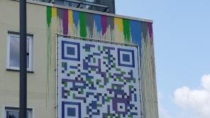 An der Fassade des Siegener SVB-Gebäudes hängt ein großer Banner mit einem QR-Code.