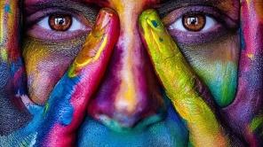 Nahaufnahme von einem Gesicht, welches bunt bemalt ist.