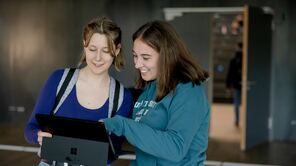 Studierende schauen gemeinsam in einen Laptop