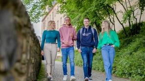 Vier Studierende laufen am Campus Unteres Schloss.
