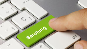 Ein Finger klickt auf einer Tastatur auf eine Taste, auf der das Wort "Beratung" steht.