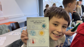 Ein Grundschüler zeigt seine Forscherkarte