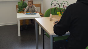 Spielende Kinder im Beobachtungslabor mit Aufsicht