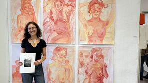 Förderpreisträgerin Vanessa Mazzei vor ihrem Kunstwerk: einer Collage aus pink-orangefarbenen Gemälden.