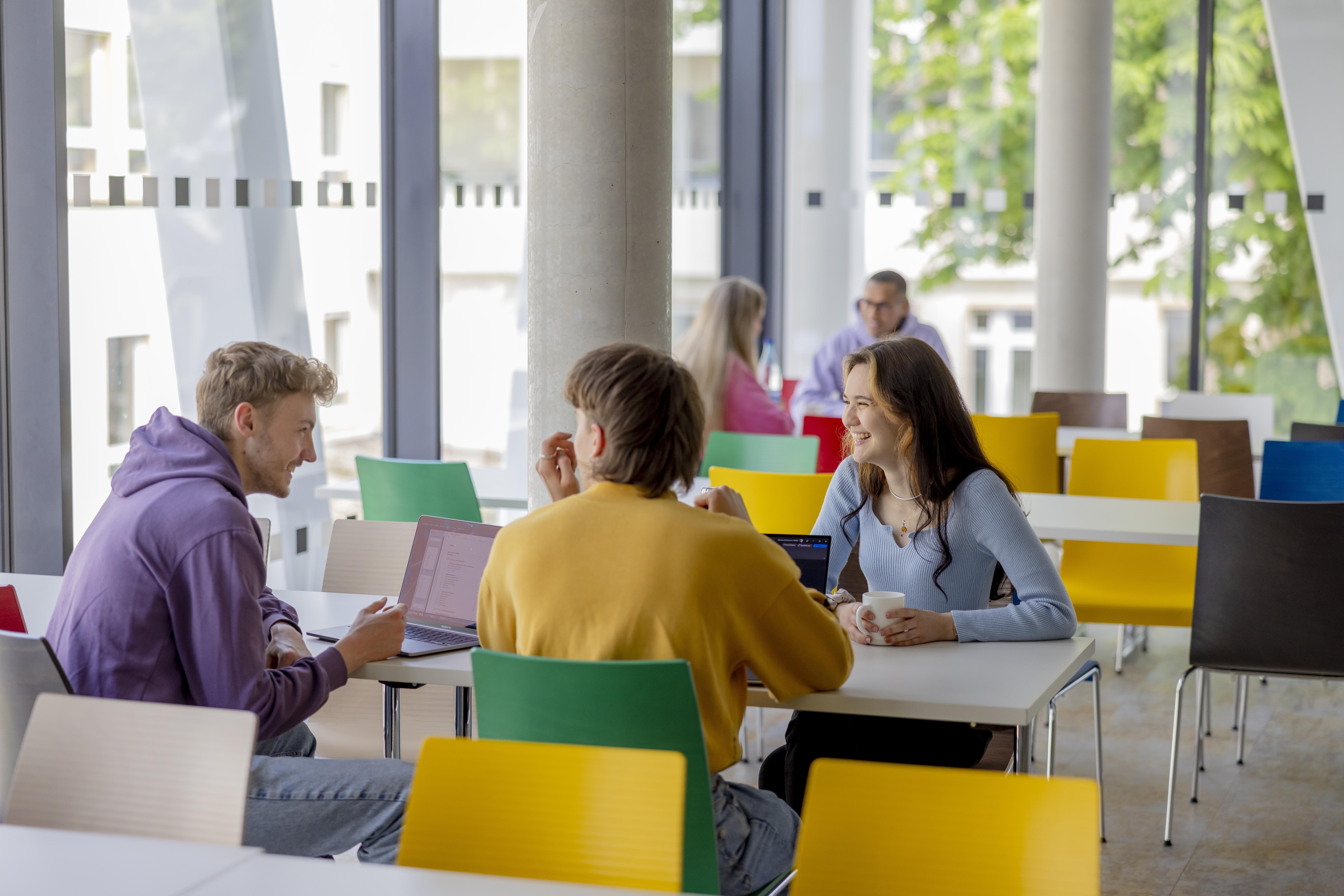 Drei Studierende sitzen am Tisch im LEO US