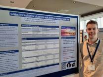 Man in front of academic poster