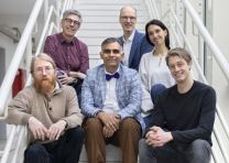 Gruppenfoto: Personen sitzen auf einer Treppe