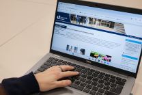 Eine Hand liegt auf der Tastatur eines Laptops.