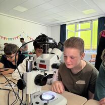 Schüler an Mikroskop in Schule