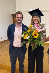 Karla Fliedner mit Doktorhut und großem Blumenstrauß neben ihrem Doktorvater Prof. Kai Horstmann