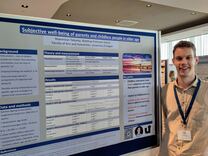 Maximilian Tolkamp neben einem wissenschaftlichen Poster auf einer Konferenz