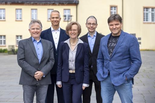 Gruppenbild auf dem Schlossplatz: Prof. Dr. Thomas Mannel, Prof. Dr. Markus Cristinziani, Prof. Dr. Stefanie Reese, Prof. Dr. Thorsten Feldmann, Prof. Dr. Alexander Lenz
