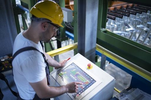 Fabrikarbeiter der Industriemaschinen und Produktion ferngesteuert im Kontrollraum überwacht
