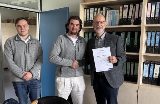 Professor Kluth erhält den Lehrpreis der Fakultät in seinem Büro überreicht