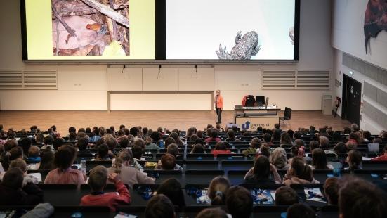 Prof. Klaudia Witte (Biologie) erklärt den Kindern im Hörsaal etwas über Frösche.
