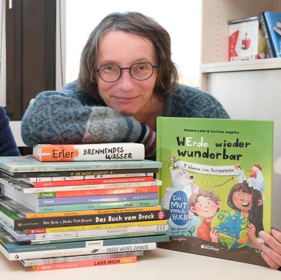 Jana Mikota mit einem Bücherstapel
