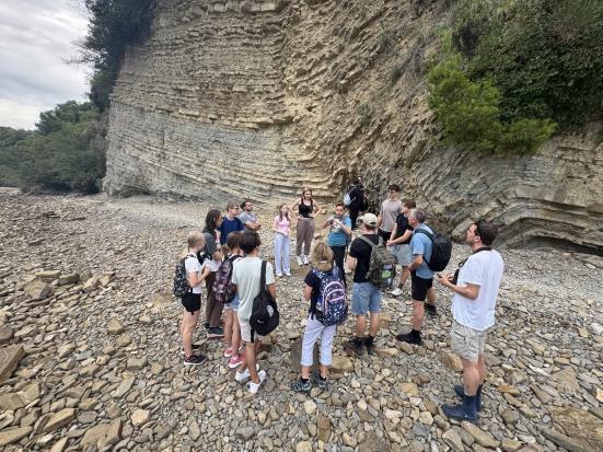 Prof. Dr. Volker Heck (Didaktik der Geographie) erläutert  die besondere Gesteinsformation Flysch einer Gruppe von Schülerinnen und Schülern des Gymnasium Ledina aus Ljubljana