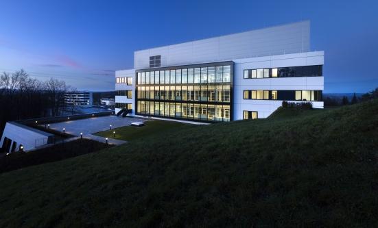 Die Rückseite des neuen Incyte-Gebäudes ist hell erleuchtet bei Morgendämmerung.