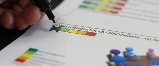 Bild, auf welchem eine Evaluation handschriftlich ausgefüllt wird.