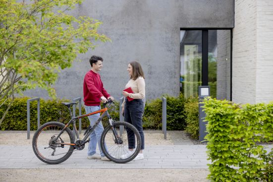 Zwei Personen unterhalten sich am Fahrrad stehend