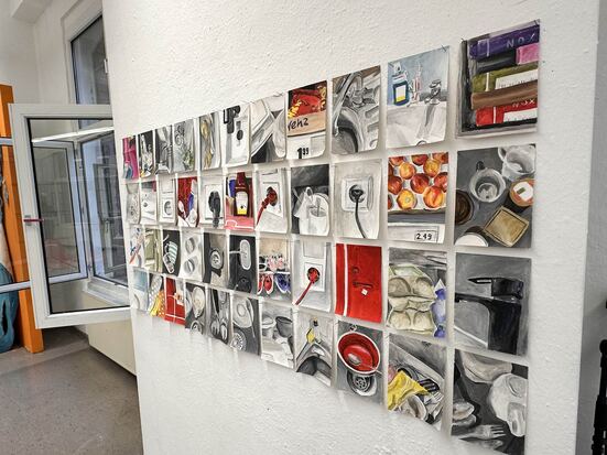 Auf einer Wand sieht man mehrere kleine Gemälde, die zu einer Collage kombiniert wurden.