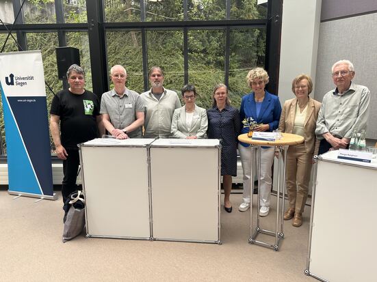 Das universi-Team steht beim Festakt zum 25-jährigen Jubiläum im Lesesaal der Uni-Bibliothek.