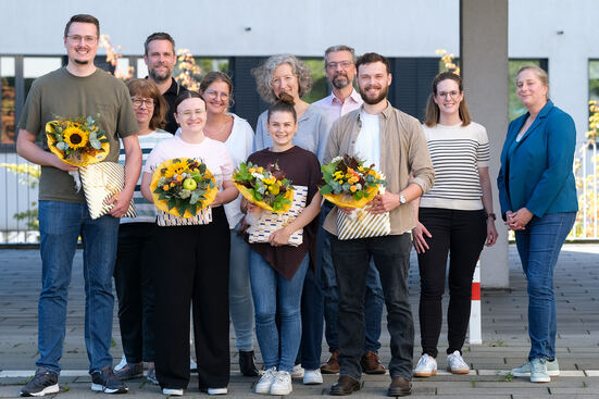 Auszubildende bekommen zum Abschluss Blumen und Geschenke