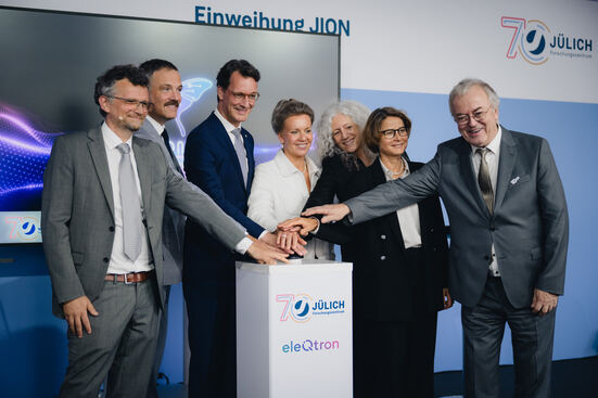 Vertreter aus Politik und der beteiligten Partner drücken gemeinsam den Knopf für den Startschuss des neuen Quantencomputers.