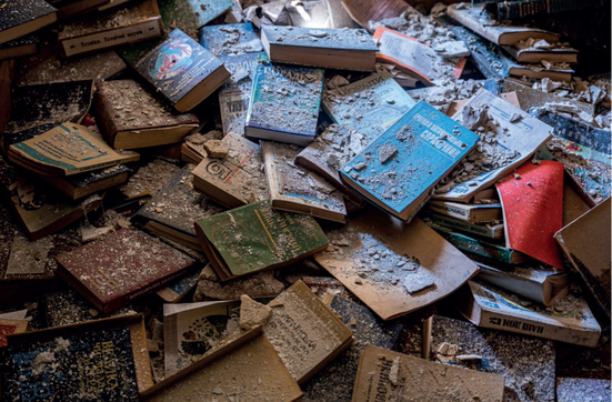 Verstreute, verstaubte Bücher nach der Zerstörung einer Bibliothek