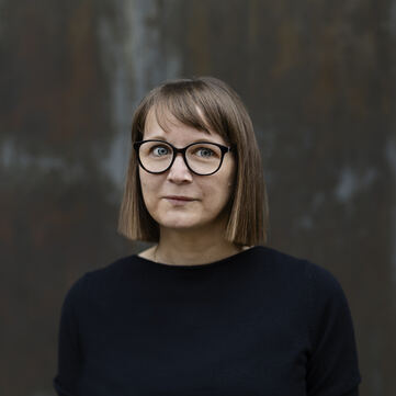 ein Foto von Daniela Wentz. Sie trägt eine schwarze Brille und hat brünette, kinnlange, glatte Haare