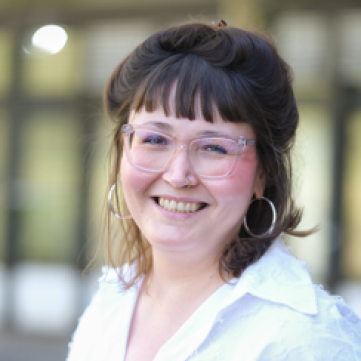Frau lachend mit weißem Hemd und Brille