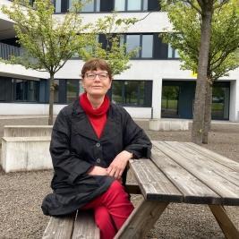 Veronika Albrecht-Birkner auf einer Bank vor dem NB-Gebäude