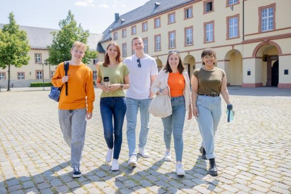 Fünf Studierende laufen über den Schlossplatz US.