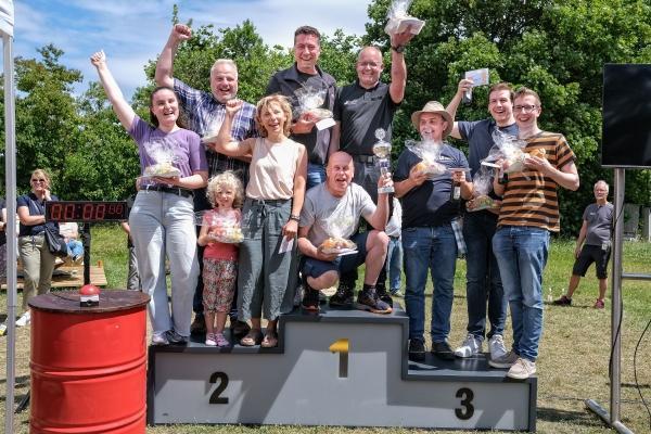 Die drei Gewinnerteams des Team-Wettbewerbs beim Beschäftigtenfest jubeln auf dem Podium.