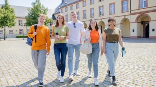 Fünf Studierende laufen über den Schlossplatz US.